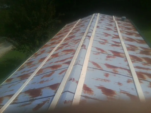 Rusted metal roof panels with new wood purlins before replacement — Storm Damage Roof Repair in Lucedale by Roofing Brothers
