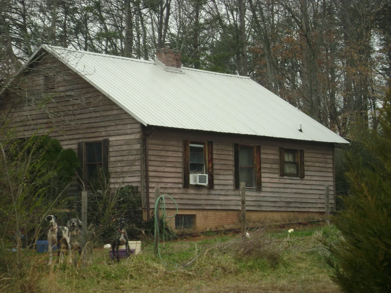 White metal roof on an old wood sided farmhouse, from a Metal Roof Installation job in Lucedale